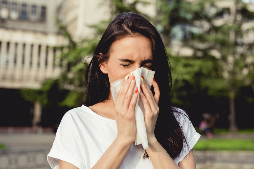 woman sneezing during spring allergy season she needs QUINTON Nasal Spray